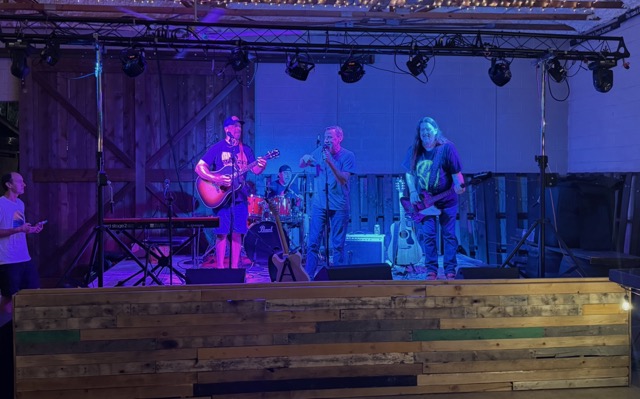 A band on the covered stage under string lights at Rocklobster Fest, Josabi's, Helotes, Texas